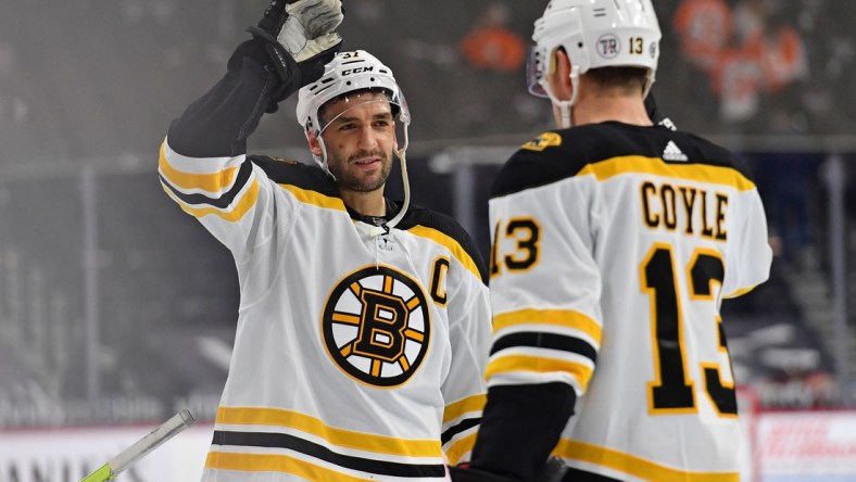 Apr 6, 2021; Philadelphia, Pennsylvania, USA; Boston Bruins center Patrice Bergeron (37) and center Charlie Coyle (13) celebrate win against the Philadelphia Flyers at Wells Fargo Center. Mandatory Credit: Eric Hartline-USA TODAY Sports