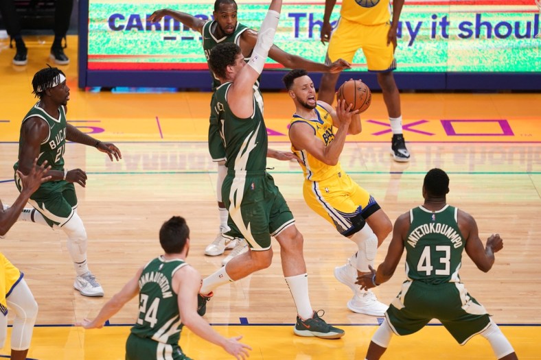 Apr 6, 2021; San Francisco, California, USA; Golden State Warriors guard Stephen Curry (30) drives past Milwaukee Bucks center Brook Lopez (11) in the first quarter at the Chase Center. Mandatory Credit: Cary Edmondson-USA TODAY Sports