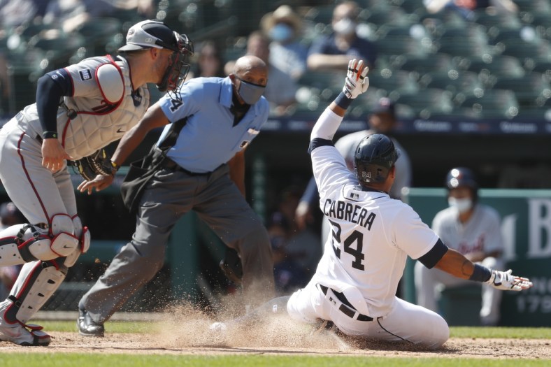 Apr 7, 2021; Detroit, Michigan, USA; Detroit Tigers first baseman Miguel Cabrera (24) slides into home plate after already getting tagged out by Minnesota Twins catcher Mitch Garver (left) during the sixth inning at Comerica Park. Mandatory Credit: Raj Mehta-USA TODAY Sports