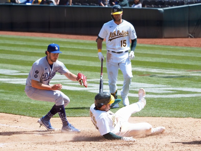 Apr 7, 2021; Oakland, California, USA; Oakland Athletics center fielder Ramon Laureano (22) slides safely home on a wild pitch by Los Angeles Dodgers starting pitcher Trevor Bauer (27) during the at bat of left fielder Seth Brown (15) during the fourth inning at RingCentral Coliseum. Mandatory Credit: Kelley L Cox-USA TODAY Sports