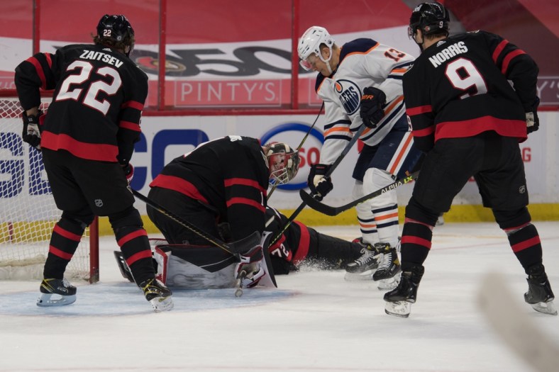 Apr 7, 2021; Ottawa, Ontario, CAN; Ottawa Senators goalie Marcus Hogberg (1) makes a save in front of Edmonton Oilers right wing Jesse Puljujarvi (13) in the first period at the Canadian Tire Centre. Mandatory Credit: Marc DesRosiers-USA TODAY Sports