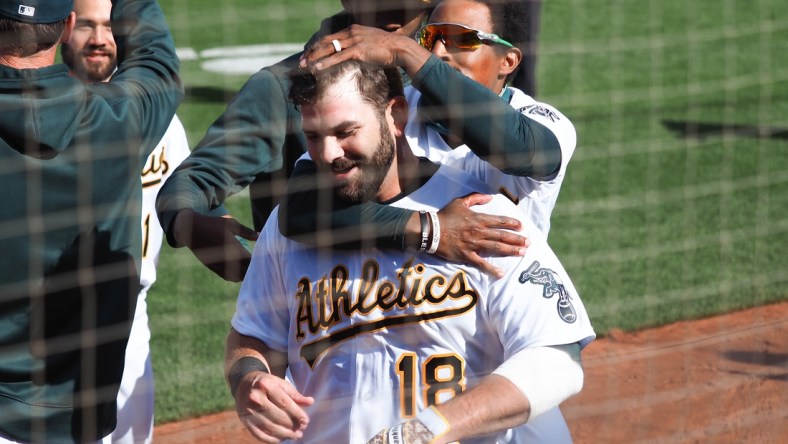 Apr 7, 2021; Oakland, California, USA; Oakland Athletics left fielder Tony Kemp (5) celebrates with first baseman Mitch Moreland (18) after Moreland hit an RBI single for a walk-off win against the Los Angeles Dodgers in the tenth inning at RingCentral Coliseum. Mandatory Credit: Kelley L Cox-USA TODAY Sports