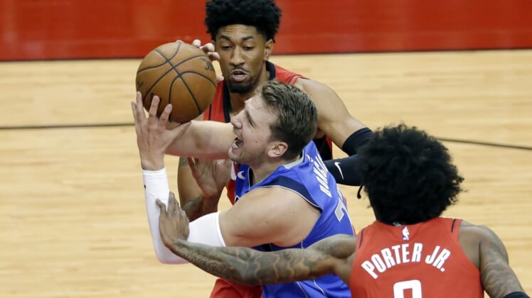 Apr 7, 2021; Houston, Texas, USA;  Dallas Mavericks guard Luka Doncic (77) is fouled as he drives to the basket between during the first half of an NBA basketball game at Toyota Center. Mandatory Credit:  Michael Wyke/POOL PHOTOS-USA TODAY Sports
