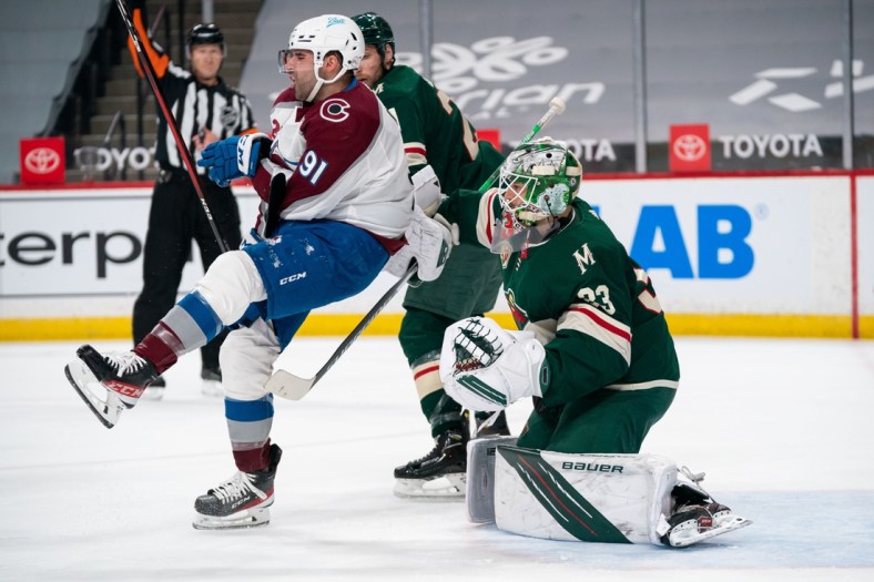 Apr 7, 2021; Saint Paul, Minnesota, USA;  Colorado Avalanche forward Nazem Kadri (91) is cross checked in front of Minnesota Wild goalie Cam Talbot (33) in the first period at Xcel Energy Center. Mandatory Credit: Brad Rempel-USA TODAY Sports