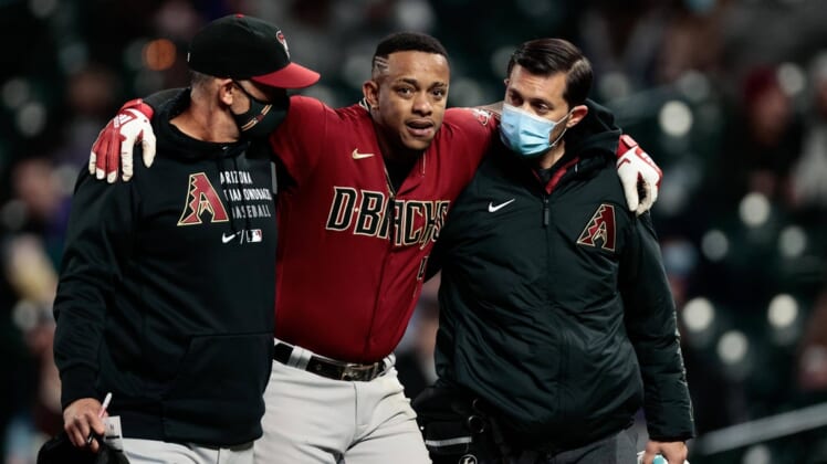 Apr 7, 2021; Denver, Colorado, USA; Arizona Diamondbacks center fielder Ketel Marte (4) is helped off the field by quality control/catching coach Robby Hammock (left) and head athletic trainer Ryan DiPanfilo (right) in the fifth inning against the Colorado Rockies at Coors Field. Mandatory Credit: Isaiah J. Downing-USA TODAY Sports