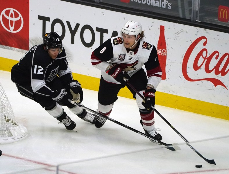 Apr 7, 2021; Los Angeles, California, USA; Arizona Coyotes defenseman Jakob Chychrun (6) moves the puck against Los Angeles Kings center Trevor Moore (12) during the first period at Staples Center. Mandatory Credit: Gary A. Vasquez-USA TODAY Sports