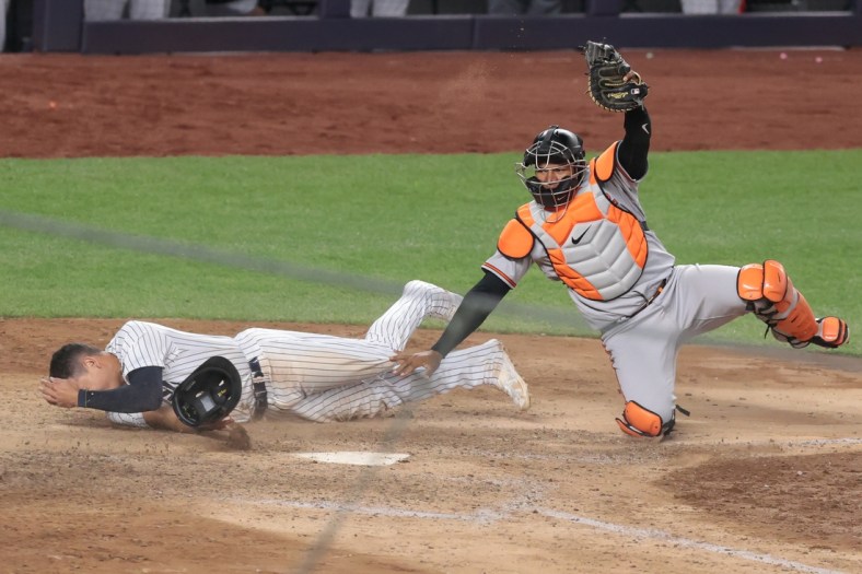 Apr 7, 2021; Bronx, New York, USA; Baltimore Orioles catcher Pedro Severino (28) tags out New York Yankees third baseman Gio Urshela (29) at home plate to the end the game on a double play in the eleventh inning at Yankee Stadium. Mandatory Credit: Vincent Carchietta-USA TODAY Sports