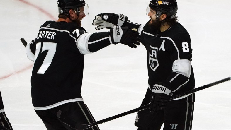 Apr 7, 2021; Los Angeles, California, USA; Los Angeles Kings center Jeff Carter (77) celebrates with defenseman Drew Doughty (8) his goal scored against the Arizona Coyotes during the third period at Staples Center. Mandatory Credit: Gary A. Vasquez-USA TODAY Sports