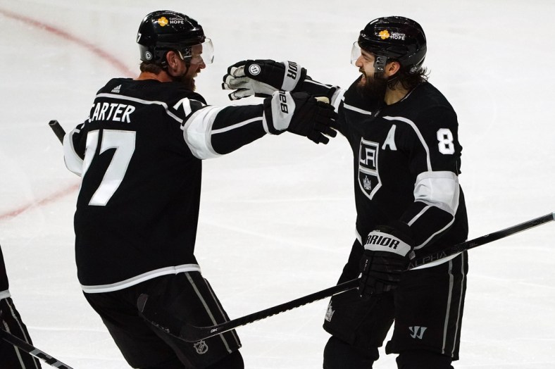 Apr 7, 2021; Los Angeles, California, USA; Los Angeles Kings center Jeff Carter (77) celebrates with defenseman Drew Doughty (8) his goal scored against the Arizona Coyotes during the third period at Staples Center. Mandatory Credit: Gary A. Vasquez-USA TODAY Sports