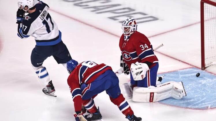 Apr 8, 2021; Montreal, Quebec, CAN; Winnipeg Jets left wing Adam Lowry (17) celebrates a goal by defenseman Josh Morrissey (not pictured) against Montreal Canadiens goaltender Jake Allen (34) and during the first period at Bell Centre. Mandatory Credit: Jean-Yves Ahern-USA TODAY Sports
