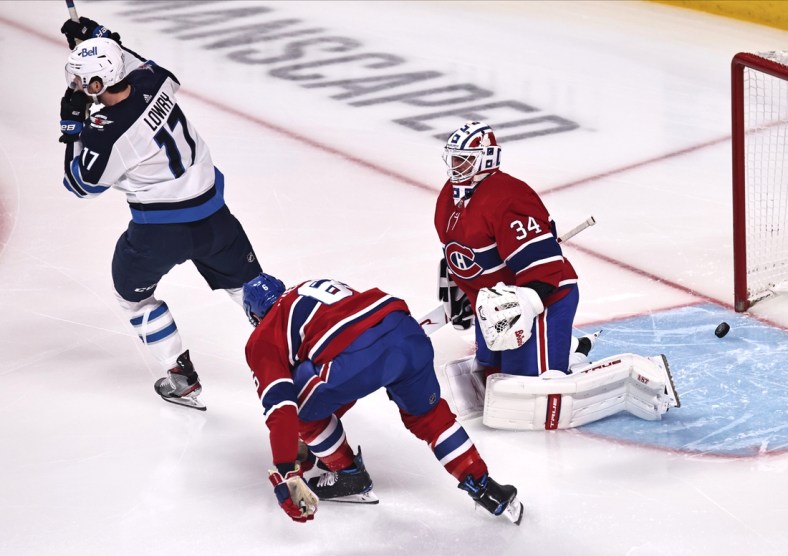 Apr 8, 2021; Montreal, Quebec, CAN; Winnipeg Jets left wing Adam Lowry (17) celebrates a goal by defenseman Josh Morrissey (not pictured) against Montreal Canadiens goaltender Jake Allen (34) and during the first period at Bell Centre. Mandatory Credit: Jean-Yves Ahern-USA TODAY Sports