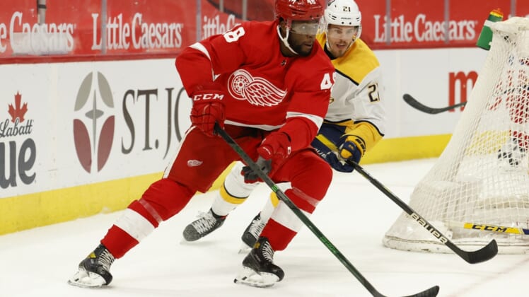 Apr 8, 2021; Detroit, Michigan, USA;  Detroit Red Wings left wing Givani Smith (48) skates with the puck chased by Nashville Predators center Nick Cousins (21) in the second period at Little Caesars Arena. Mandatory Credit: Rick Osentoski-USA TODAY Sports