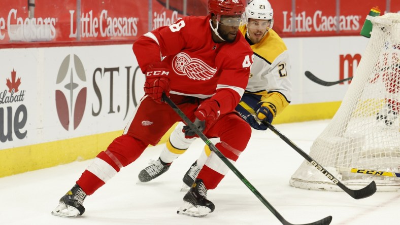 Apr 8, 2021; Detroit, Michigan, USA;  Detroit Red Wings left wing Givani Smith (48) skates with the puck chased by Nashville Predators center Nick Cousins (21) in the second period at Little Caesars Arena. Mandatory Credit: Rick Osentoski-USA TODAY Sports