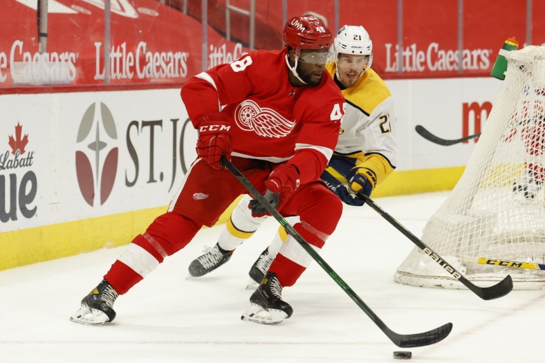 Apr 8, 2021; Detroit, Michigan, USA;  Detroit Red Wings left wing Givani Smith (48) skates with the puck chased by Nashville Predators center Nick Cousins (21) in the second period at Little Caesars Arena. Mandatory Credit: Rick Osentoski-USA TODAY Sports