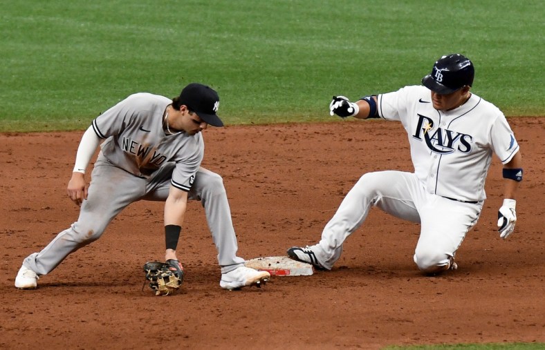 Apr 9, 2021; St. Petersburg, Florida, USA; Tampa Bay Rays designated hitter Yoshi Tsutsugo (25) slides into second base as New York Yankees infielder Tyler Wade (14) fields the throw from the outfield in the fifth inning at Tropicana Field. Mandatory Credit: Jonathan Dyer-USA TODAY Sports