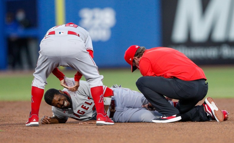 Apr 9, 2021; Dunedin, Florida, CAN; Los Angeles Angels right fielder Dexter Fowler (25) is attended to by manager Joe Maddon (left) after injuring his knee on a slide into second base in a game against the Toronto Blue Jays t TD Ballpark. Mandatory Credit: Nathan Ray Seebeck-USA TODAY Sports