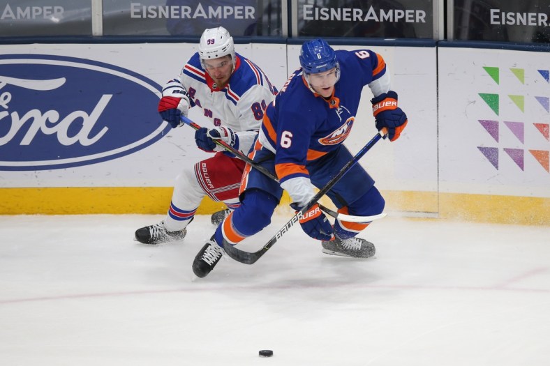 Apr 9, 2021; Uniondale, New York, USA; New York Rangers right wing Pavel Buchnevich (89) and New York Islanders defenseman Ryan Pulock (6) fight for the puck during the third period at Nassau Veterans Memorial Coliseum. Mandatory Credit: Brad Penner-USA TODAY Sports