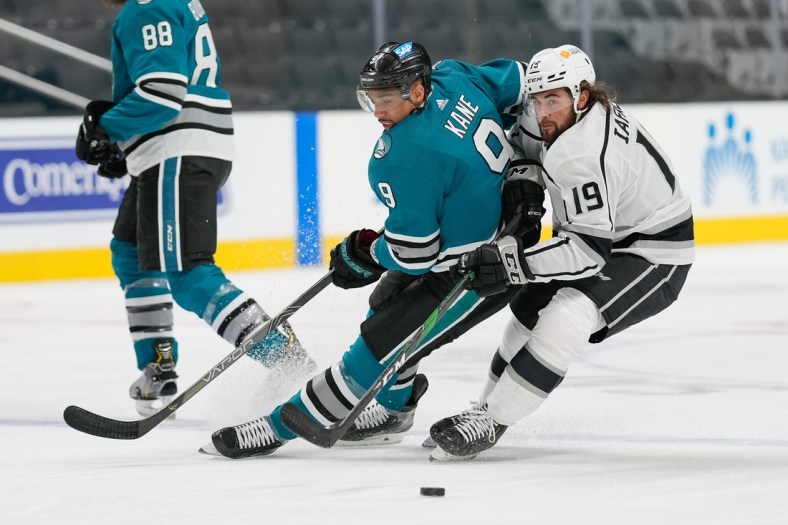 Apr 9, 2021; San Jose, California, USA; San Jose Sharks left wing Evander Kane (9) and Los Angeles Kings right wing Alex Iafallo (19) chase after the puck during the first period at SAP Center at San Jose. Mandatory Credit: Stan Szeto-USA TODAY Sports