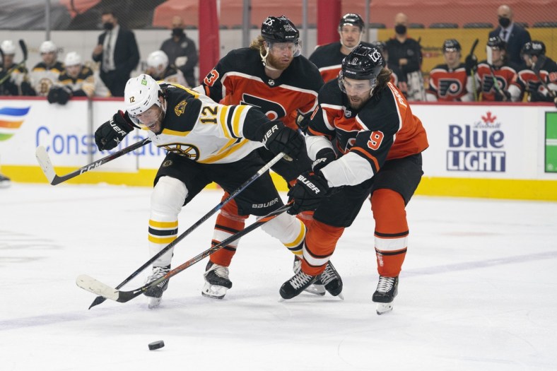 Apr 10, 2021; Philadelphia, Pennsylvania, USA; Boston Bruins right wing Craig Smith (12) battles for the puck against Philadelphia Flyers right wing Jakub Voracek (93) and defenseman Ivan Provorov (9) in the first period at the Wells Fargo Center. Mandatory Credit: Mitchell Leff-USA TODAY Sports