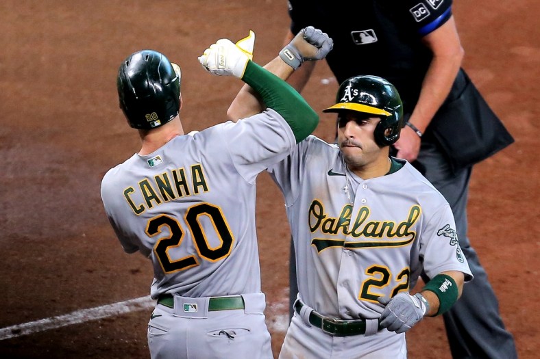 Apr 10, 2021; Houston, Texas, USA; Oakland Athletics center fielder Ramon Laureano (22, right) is congratulated by Oakland Athletics left fielder Mark Canha (20) after hitting a two-run home run against the Houston Astros during the fifth inning at Minute Maid Park. Mandatory Credit: Erik Williams-USA TODAY Sports
