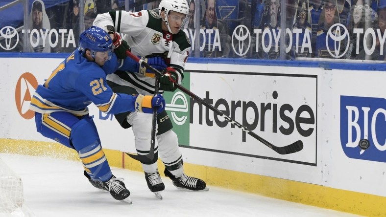 Apr 10, 2021; St. Louis, Missouri, USA; St. Louis Blues center Tyler Bozak (21) checks Minnesota Wild center Nico Sturm (7) in the first period at Enterprise Center. Mandatory Credit: Jeff Le-USA TODAY Sports