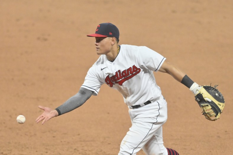 Apr 10, 2021; Cleveland, Ohio, USA; Cleveland Indians first baseman Yu Chang (2) tosses the ball to first base in the seventh inning against the Detroit Tigers at Progressive Field. Mandatory Credit: David Richard-USA TODAY Sports
