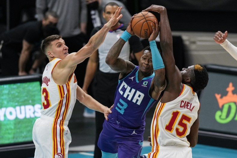 Apr 11, 2021; Charlotte, North Carolina, USA; Charlotte Hornets guard Terry Rozier (3) gets fouled going up for a shot defended by Atlanta Hawks center Clint Capela (15) and guard Bogdan Bogdanovic (13) during the second quarter at Spectrum Center. Mandatory Credit: Jim Dedmon-USA TODAY Sports