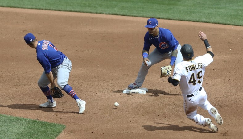 Apr 11, 2021; Pittsburgh, Pennsylvania, USA;  Chicago Cubs second baseman Eric Sogard (4) flips the ball between his legs to shortstop Javier Baez (9) for a forceout of Pittsburgh Pirates center fielder Dustin Fowler (49) at second base during the third inning at PNC Park. Mandatory Credit: Charles LeClaire-USA TODAY Sports