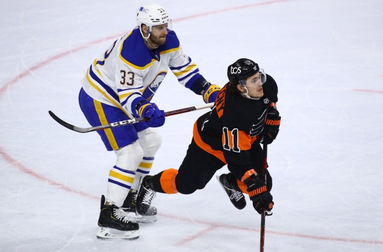 Apr 11, 2021; Philadelphia, Pennsylvania, USA; Buffalo Sabres defenceman Colin Miller (33) hits Philadelphia Flyers right wing Travis Konecny (11) in the first period at Wells Fargo Center. Mandatory Credit: Kyle Ross-USA TODAY Sports
