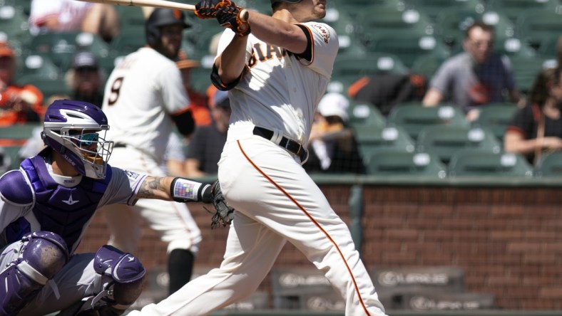 Apr 11, 2021; San Francisco, California, USA; San Francisco Giants batter Alex Dickerson (12) follows through on his solo home run again the Colorado Rockies during the first inning of a Major League Baseball game at Oracle Park. Mandatory Credit: D. Ross Cameron-USA TODAY Sports