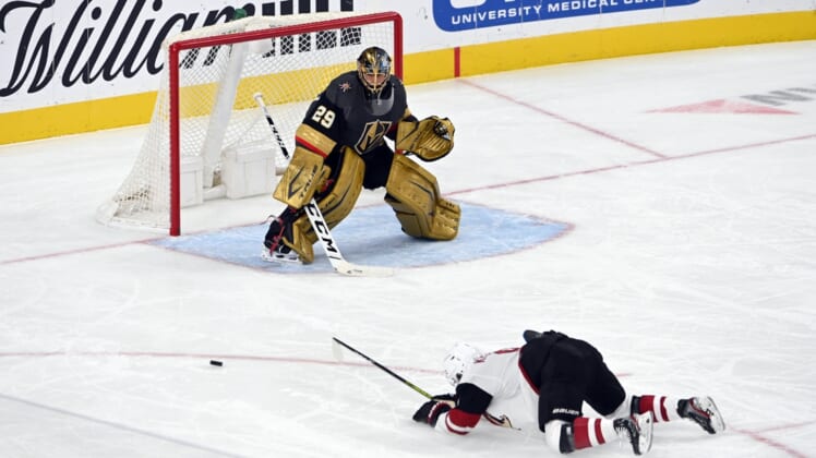 Apr 11, 2021; Las Vegas, NV, USA; Arizona Coyotes right wing Clayton Keller (9) slips on the ice as Vegas Golden Knights goaltender Marc-Andre Fleury (29) defends during the second period at T-Mobile Arena. (Mandatory Credit: David Beckeri-USA TODAY Sports via The Associated Press)