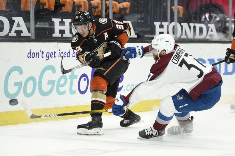 Apr 11, 2021; Anaheim, California, USA; Anaheim Ducks right wing Jakob Silfverberg (33) clears the puck away from Colorado Avalanche left wing J.T. Compher (37) during the first period at Honda Center. Mandatory Credit: Kelvin Kuo-USA TODAY Sports
