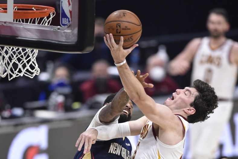 Apr 11, 2021; Cleveland, Ohio, USA; Cleveland Cavaliers forward Cedi Osman (16) goes to the basket while defended by New Orleans Pelicans forward James Johnson (16) during the second quarter at Rocket Mortgage FieldHouse. Mandatory Credit: David Richard-USA TODAY Sports