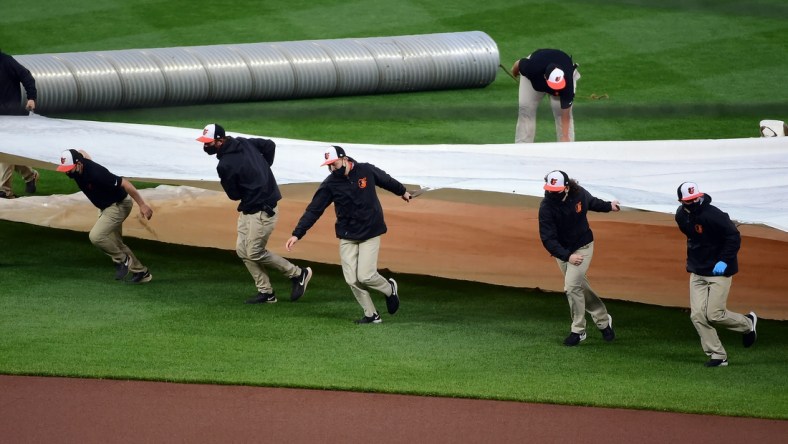 Apr 12, 2021; Baltimore, Maryland, USA; Members of the grounds crew put the tarp on the field prior to a game between the Seattle Mariners and Baltimore Orioles at Oriole Park at Camden Yards. Mandatory Credit: Evan Habeeb-USA TODAY Sports