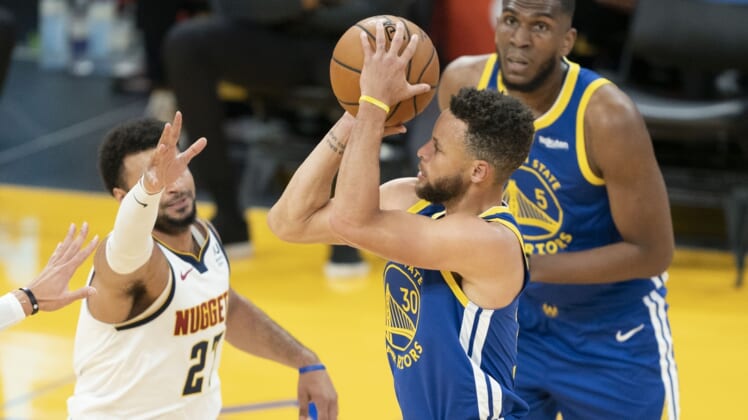 April 12, 2021; San Francisco, California, USA; Golden State Warriors guard Stephen Curry (30) shoots the basketball against Denver Nuggets guard Jamal Murray (27) during the first quarter at Chase Center. Mandatory Credit: Kyle Terada-USA TODAY Sports