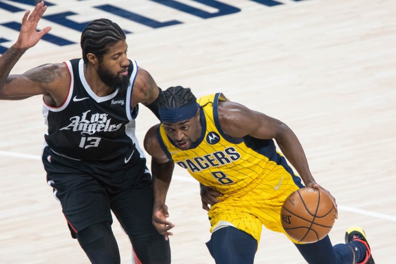 Apr 13, 2021; Indianapolis, Indiana, USA; Indiana Pacers forward Justin Holiday (8) dribbles the ball while LA Clippers guard Paul George (13) defends  in the first quarter at Bankers Life Fieldhouse. Mandatory Credit: Trevor Ruszkowski-USA TODAY Sports