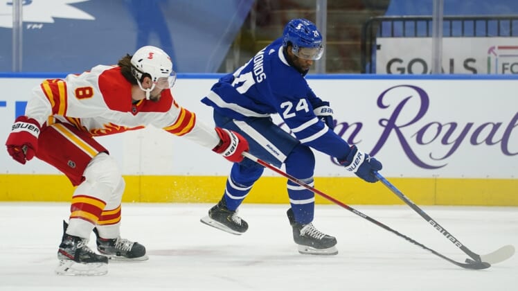 Apr 13, 2021; Toronto, Ontario, CAN; Calgary Flames defenseman Christopher Tanev (8) defends against Toronto Maple Leafs forward Wayne Simmonds (24) during the first period at Scotiabank Arena. Mandatory Credit: John E. Sokolowski-USA TODAY Sports