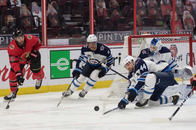 Apr 14, 2021; Ottawa, Ontario, CAN; Ottawa Senators center Michael Amadiao (29) shoots the puck past Winnipeg Jets defenseman Josh Morrissey (44) during the first period at the Canadian Tire Centre. Mandatory Credit: Marc DesRosiers-USA TODAY Sports