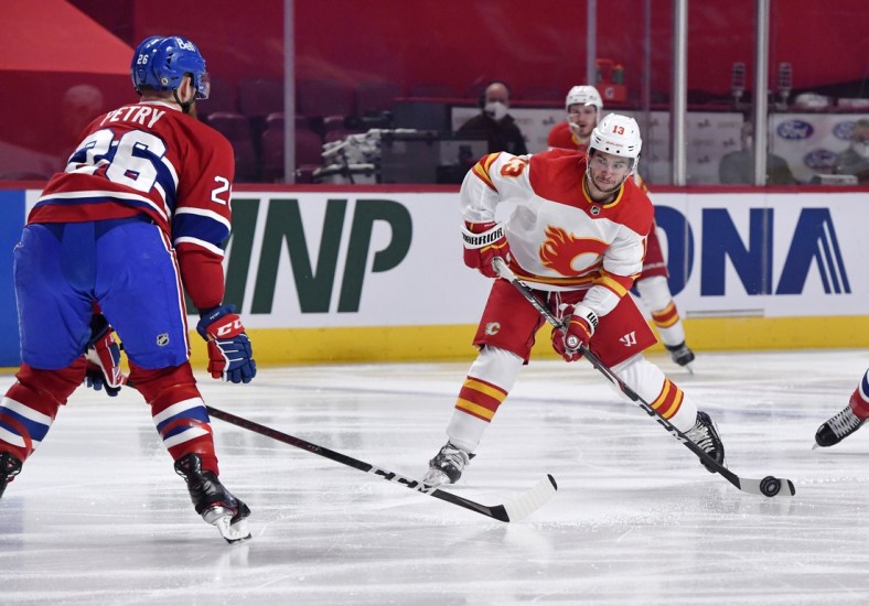 Apr 14, 2021; Montreal, Quebec, CAN; Calgary Flames forward Johnny Gaudreau (13) shoots the puck and Montreal Canadiens defenseman Jeff Petry (26) attempts to block during the first period at the Bell Centre. Mandatory Credit: Eric Bolte-USA TODAY Sports