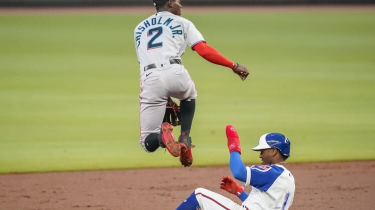 Apr 14, 2021; Cumberland, Georgia, USA; Miami Marlins second baseman Jazz Chisholm Jr. (2) jumps over Atlanta Braves second baseman Ozzie Albies (1) as he throws to first base to complete a double play during the second inning at Truist Park. Mandatory Credit: Dale Zanine-USA TODAY Sports