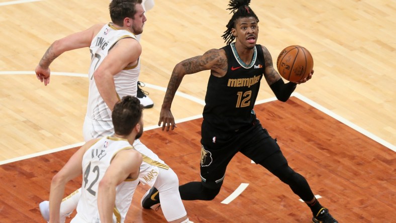 Apr 14, 2021; Memphis, Tennessee, USA; Memphis Grizzlies guard Ja Morant (12) drives to the basket as  Dallas Mavericks guard Luka Doncic (77) defends during the second quarter at FedExForum. Mandatory Credit: Nelson Chenault-USA TODAY Sports