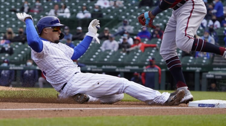 Apr 16, 2021; Chicago, Illinois, USA; Chicago Cubs shortstop Javier Baez slides safely into third base against the Atlanta Braves during the second inning at Wrigley Field. All players on both teams are wearing number 42 in honor of Jackie Robinson Day. Mandatory Credit: David Banks-USA TODAY Sports