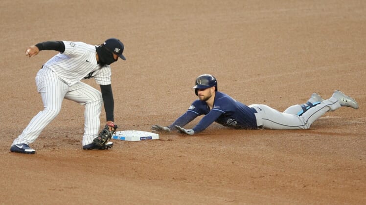 Apr 16, 2021; Bronx, New York, USA; Tampa Bay Rays second baseman Brandon Lowe slides safely into second with a two-run double ahead of the tag by New York Yankees shortstop Gleyber Torres during the first inning at Yankee Stadium. Mandatory Credit: Brad Penner-USA TODAY Sports