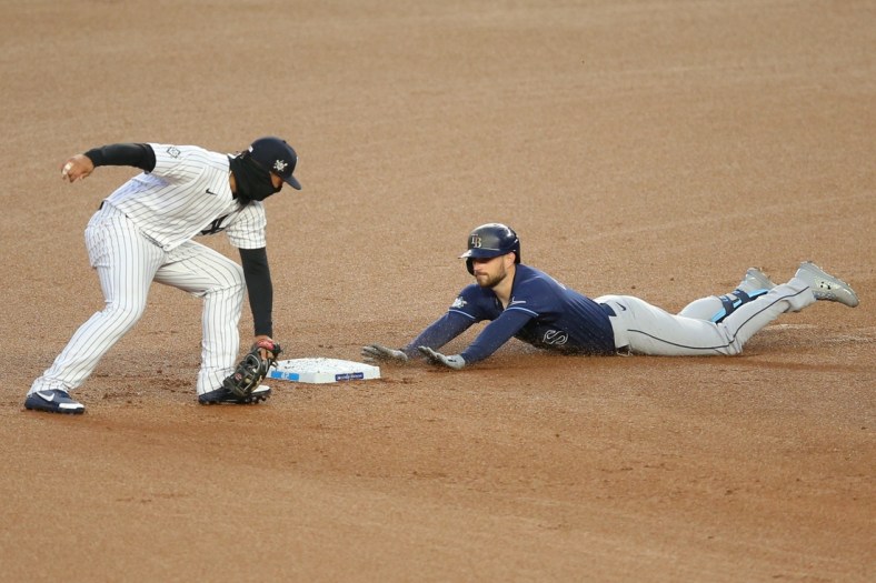 Apr 16, 2021; Bronx, New York, USA; Tampa Bay Rays second baseman Brandon Lowe slides safely into second with a two-run double ahead of the tag by New York Yankees shortstop Gleyber Torres during the first inning at Yankee Stadium. Mandatory Credit: Brad Penner-USA TODAY Sports