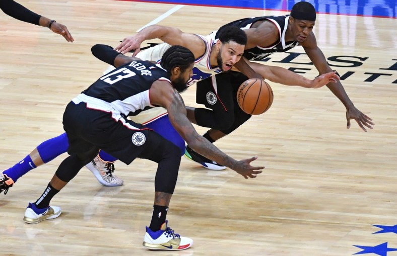 Apr 16, 2021; Philadelphia, Pennsylvania, USA; Philadelphia 76ers guard Ben Simmons (25) dives for loose ball with LA Clippers guard Paul George (13) and guard Rajon Rondo (4) during the second quarter at Wells Fargo Center. Mandatory Credit: Eric Hartline-USA TODAY Sports