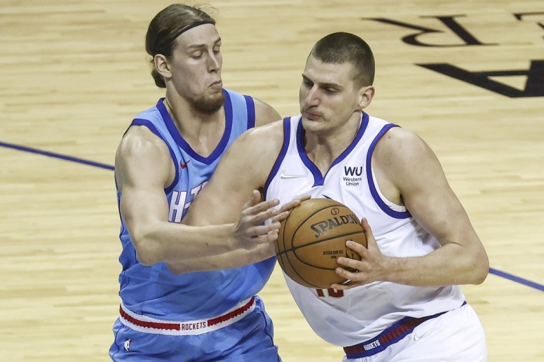 Apr 16, 2021; Houston, Texas, USA; Denver Nuggets center Nikola Jokic (15) drives with the ball as Houston Rockets forward Kelly Olynyk (41) defends during the first quarter at Toyota Center. Mandatory Credit: Troy Taormina-USA TODAY Sports