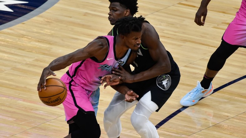 Apr 16, 2021; Minneapolis, Minnesota, USA; Miami Heat forward Jimmy Butler (22) handles the ball while defended by Minnesota Timberwolves forward Anthony Edwards (1) during the first quarter at Target Center. Mandatory Credit: Jeffrey Becker-USA TODAY Sports