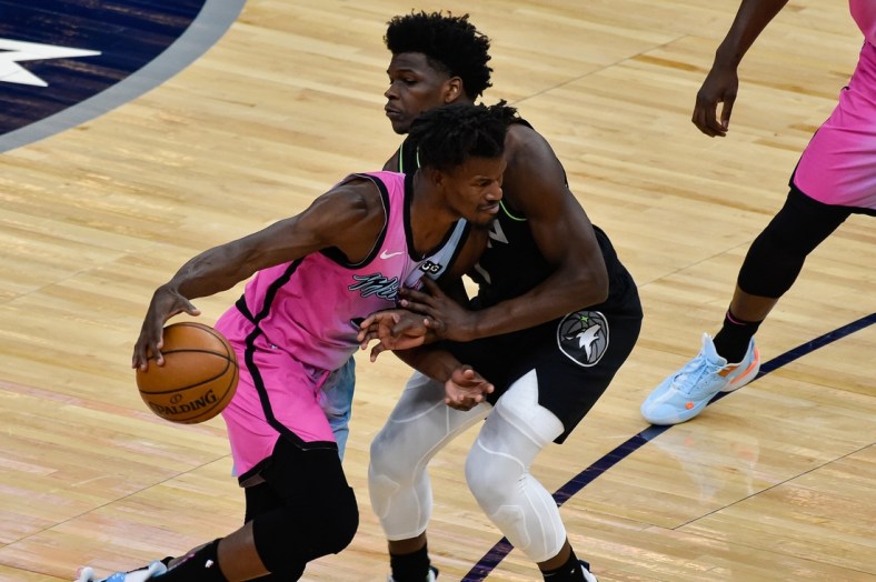 Apr 16, 2021; Minneapolis, Minnesota, USA; Miami Heat forward Jimmy Butler (22) handles the ball while defended by Minnesota Timberwolves forward Anthony Edwards (1) during the first quarter at Target Center. Mandatory Credit: Jeffrey Becker-USA TODAY Sports