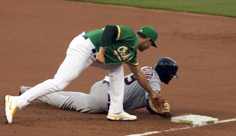 Apr 16, 2021; Oakland, California, USA; Detroit Tigers baserunner Willi Castro (9) beats a snap pickoff throw to Oakland Athletics first baseman Matt Olson during the first inning of a Major League Baseball game at RingCentral Coliseum. Mandatory Credit: D. Ross Cameron-USA TODAY Sports