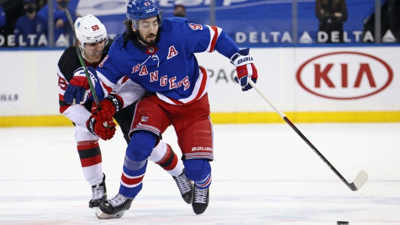 Apr 17, 2021; New York, New York, USA; anne Kuokkanen #59 of the New Jersey Devils holds back Mika Zibanejad #93 of the New York Rangers during the second period at Madison Square Garden. Mandatory Credit:  POOL PHOTOS-USA TODAY Sports